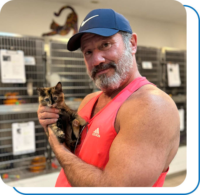 Buff man holding tiny kitten